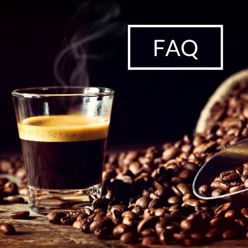 Frischer Espresso im Glas mit Kaffeebohnen drumherum