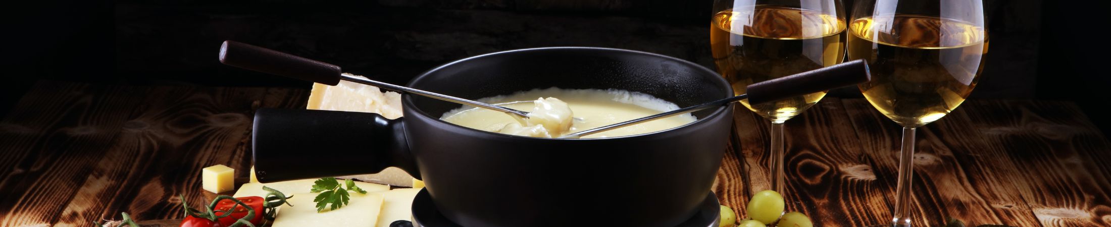 Käsefondue mit Zutaten auf einem gedeckten Tisch