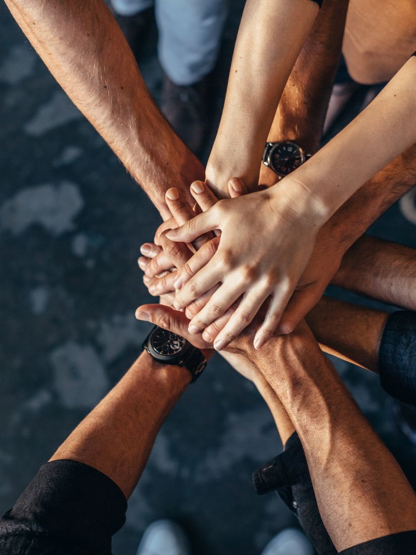 Teamwork - viele Hände liegen übereinander